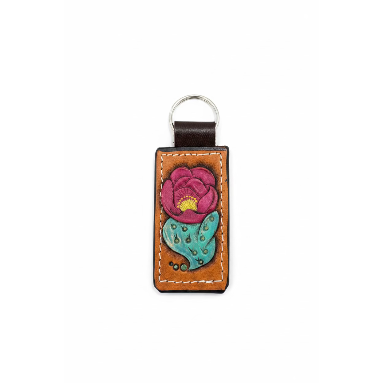 A handcrafted brown leather keychain featuring a hand-painted lotus flower with pink petals, a yellow center, and a teal-green stamen, resting on a rustic wooden surface.