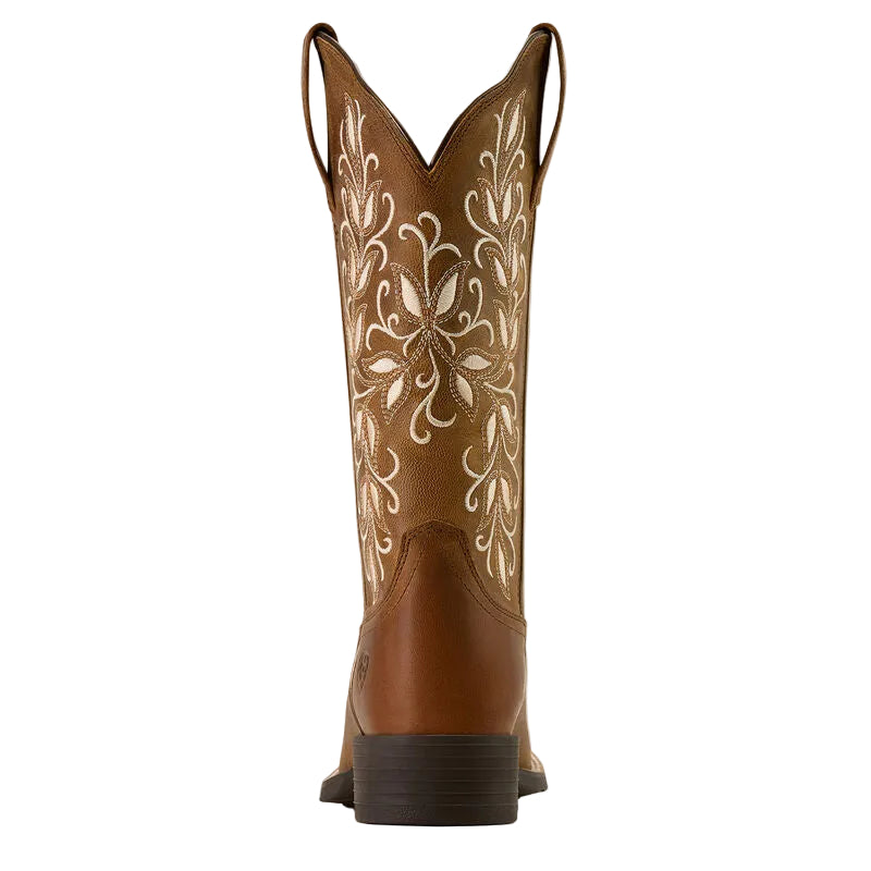 Brown cowboy boot with intricate white embroidery on a beige background