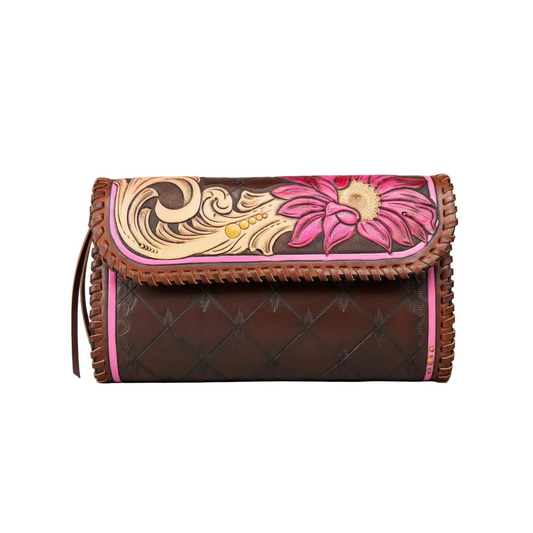 A brown leather clutch bag with a hand-tooled floral design on the flap, featuring pink and beige details, a quilted pattern on the body, and pink trim, shown against a neutral gray background.